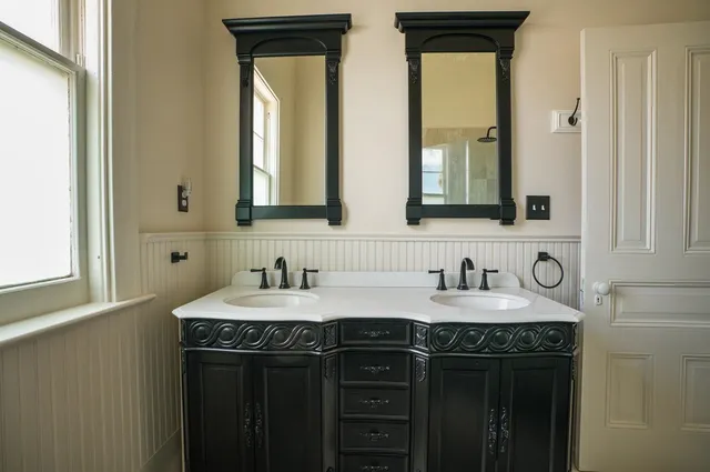 a bathroom with a granite countertop sink and a mirror