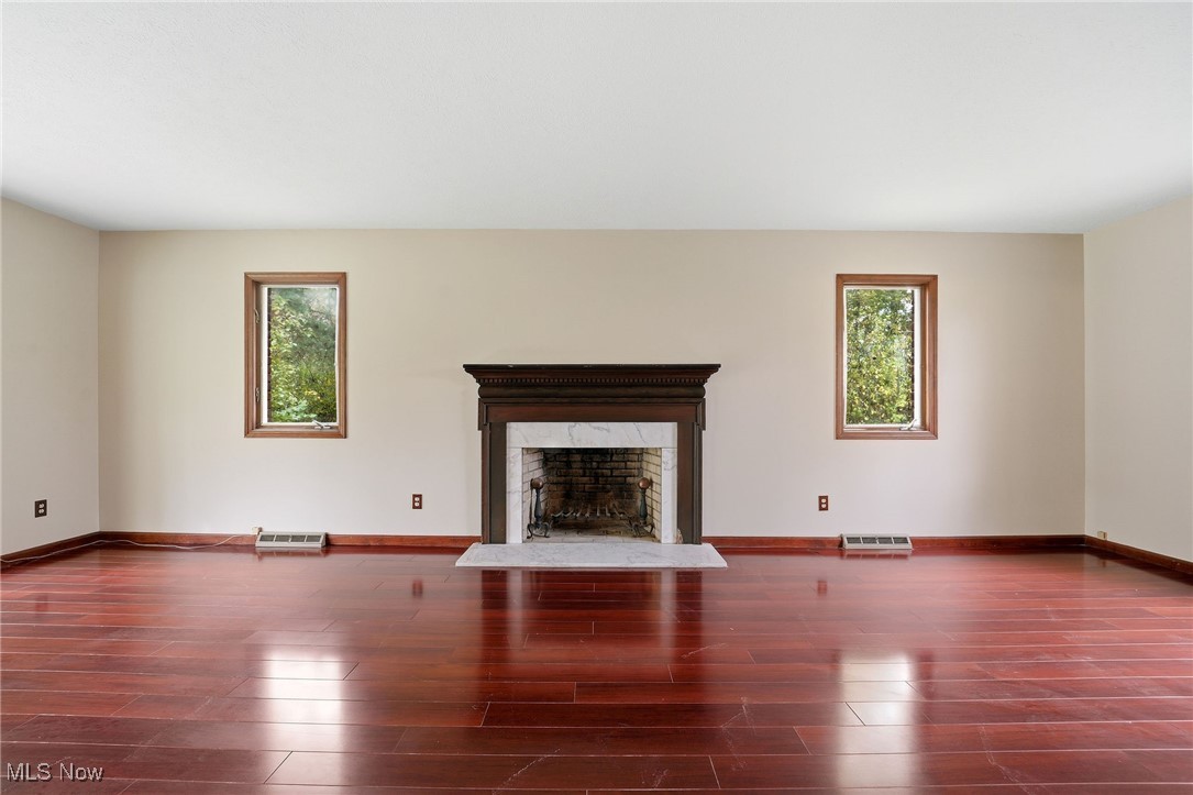 11710 Butternut Road Chardon, OH 44024 - Photo 13 of 48 Unfurnished living room featuring a wood burning fireplace, dark wood-style flooring, and plenty of natural light