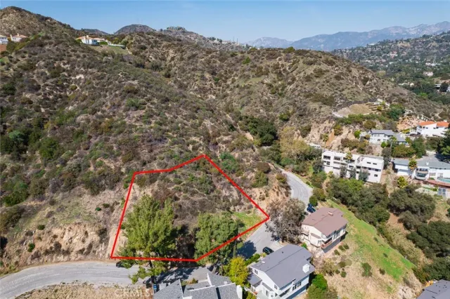 an aerial view of a house with a mountain