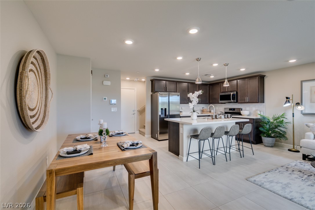 653 Pickled Pepper Place Henderson, NV 89011 - Photo 32 of 35 An open floorplan seamlessly connects the kitchen and dining area, ideal for effortless entertaining.