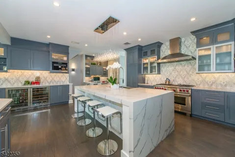 a kitchen with kitchen island granite countertop a stove and a wooden floors