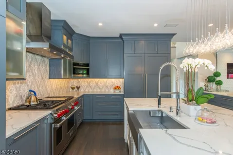 a kitchen with stainless steel appliances granite countertop a sink and a stove