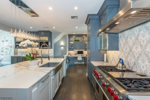 a kitchen with stainless steel appliances granite countertop a lot of counter space and a wooden floors
