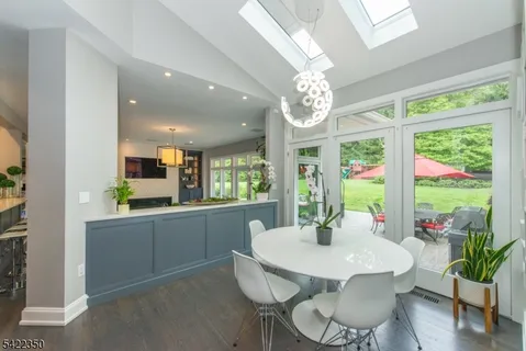 a dining room with furniture a large window and a chandelier