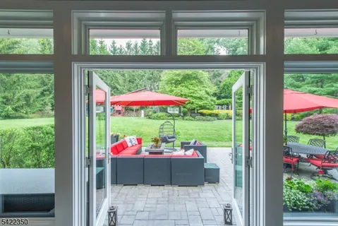 a patio with glass top table and chairs