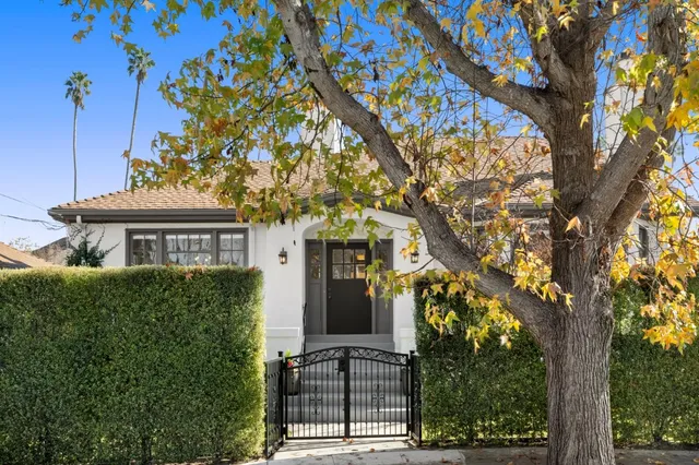 a front view of a house with a tree