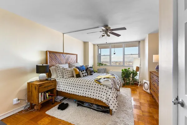 a bedroom with a bed and wooden floor