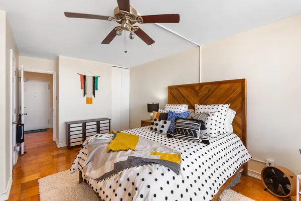 a bedroom with a bed and wooden floor