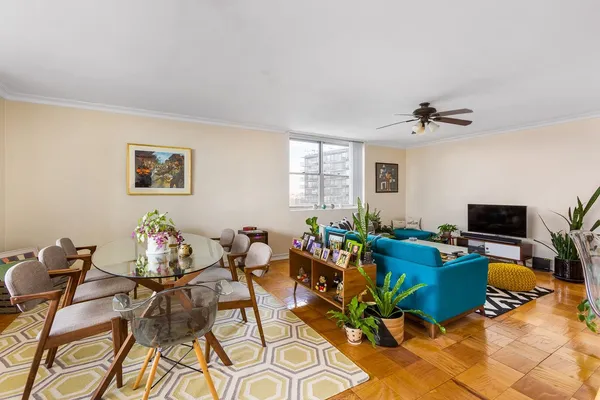 a living room with furniture a flat screen tv and a window