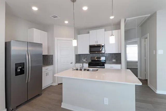 a kitchen with stainless steel appliances a refrigerator stove microwave and cabinets
