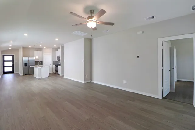 a view of an empty room with wooden floor