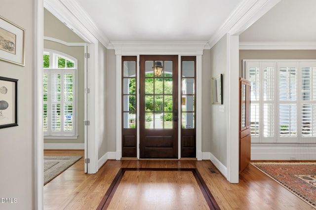 a view of a dining room with furniture a rug and wooden floor