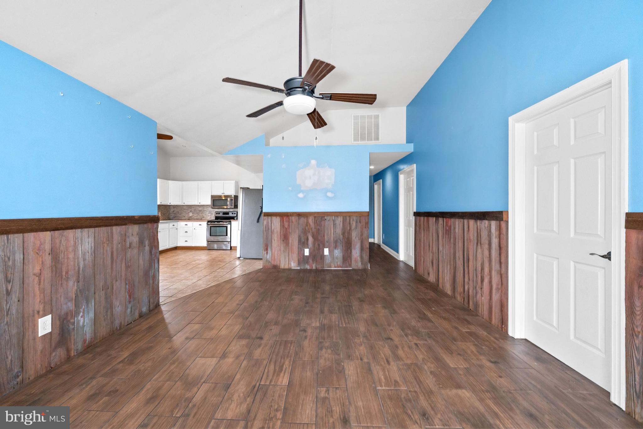 198 Cayots Corner Road Chesapeake City, MD 21915 - Photo 9 of 22 a view of a room with wooden floor a ceiling fan and windows