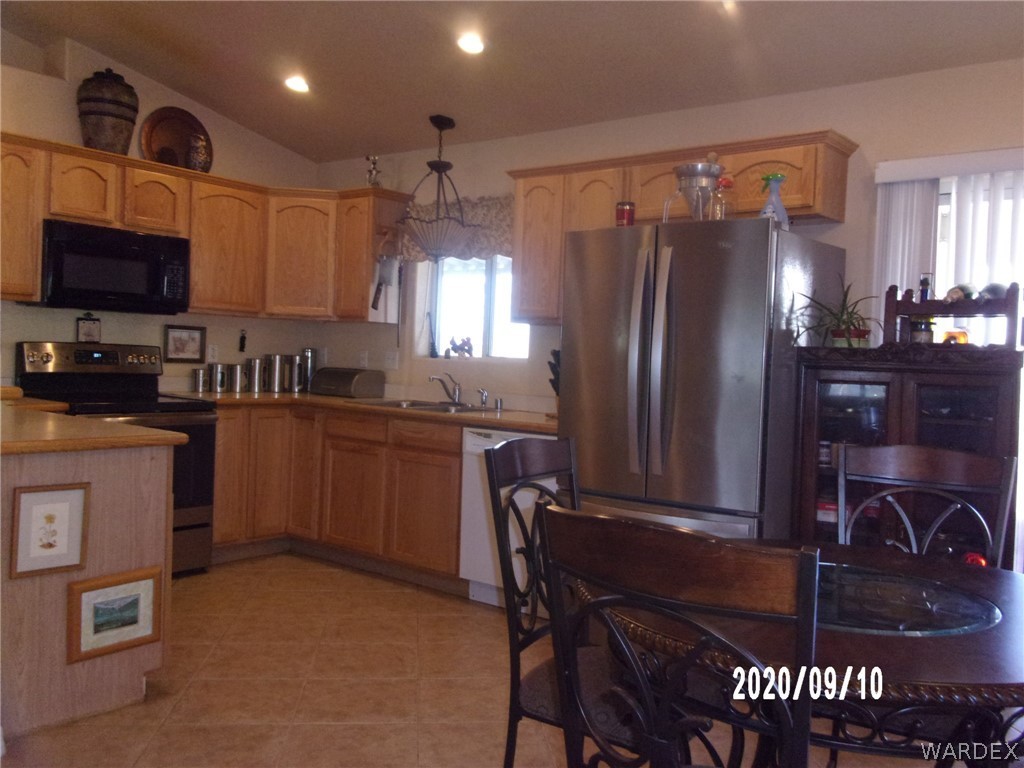 303 Bouse Road Golden Valley, AZ 86413 - Photo 22 of 42 a kitchen with a refrigerator coffee maker on the counter and dining table
