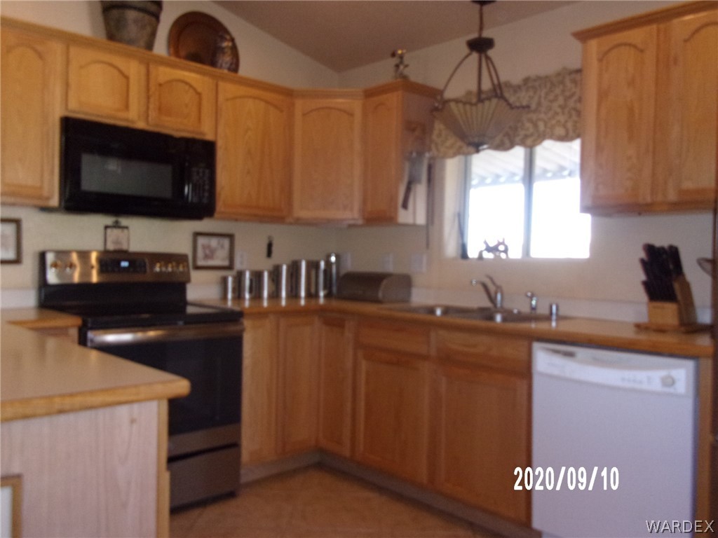303 Bouse Road Golden Valley, AZ 86413 - Photo 23 of 42 a kitchen with stainless steel appliances a stove a microwave a sink and cabinets