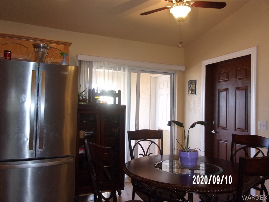 303 Bouse Road Golden Valley, AZ 86413 - Photo 27 of 42 a kitchen with stainless steel appliances granite countertop a refrigerator a stove a sink with a dining table and chairs