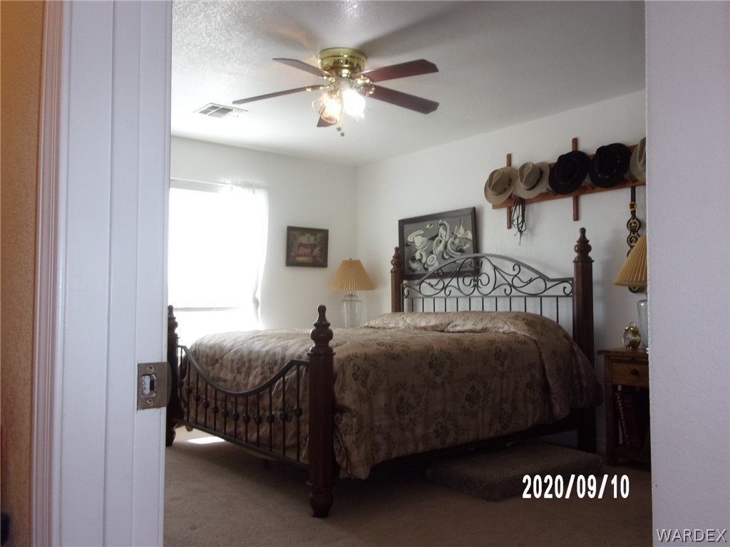 303 Bouse Road Golden Valley, AZ 86413 - Photo 33 of 42 a bedroom with a bed and a chandelier