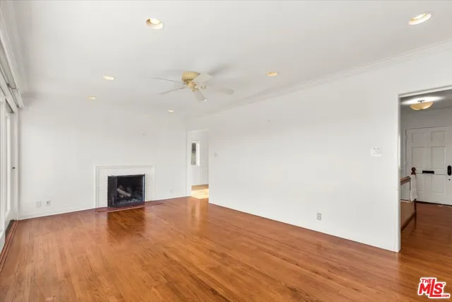 a view of empty room with wooden floor and fireplace