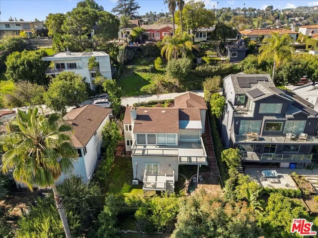 an aerial view of a house with garden space and a street view