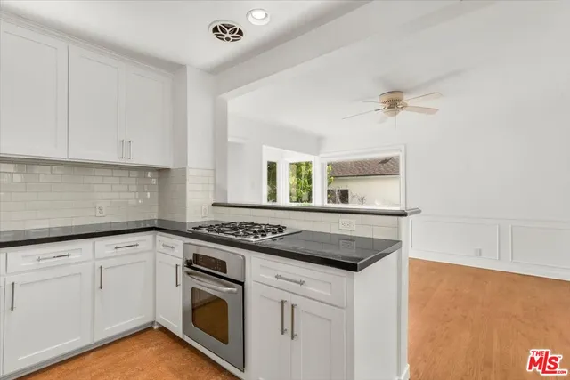 a kitchen with granite countertop white cabinets and white appliances