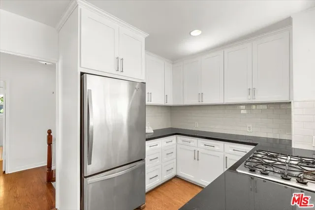 a kitchen with white cabinets and white appliances