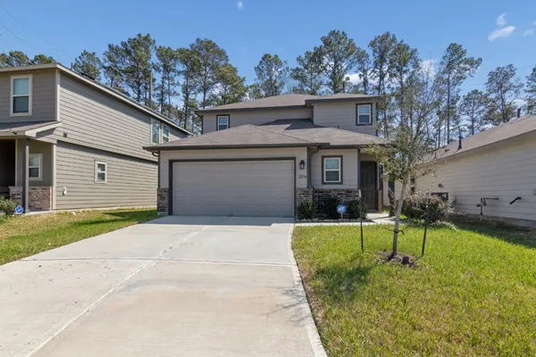 a front view of a house with a yard and garage