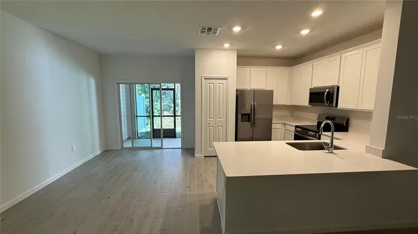 a view of a kitchen and an empty room