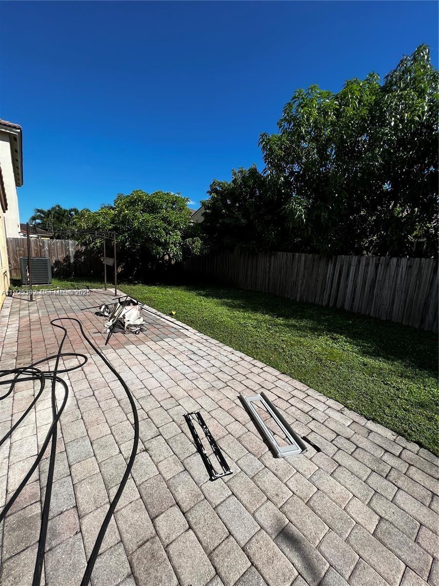 23953 Southwest 108th Court Homestead, FL 33032 - Photo 16 of 25 a view of swimming pool with seating space and trees in the background