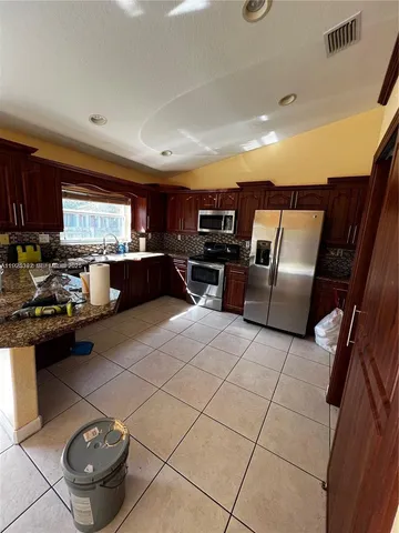 a kitchen with stainless steel appliances granite countertop a sink and a stove