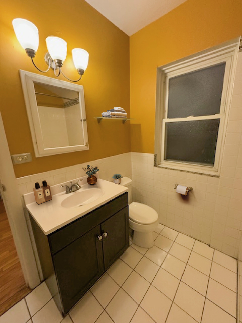 2425 West Pratt Boulevard, Unit 3I Chicago, IL 60645 - Photo 12 of 16 a bathroom with a toilet sink and mirror