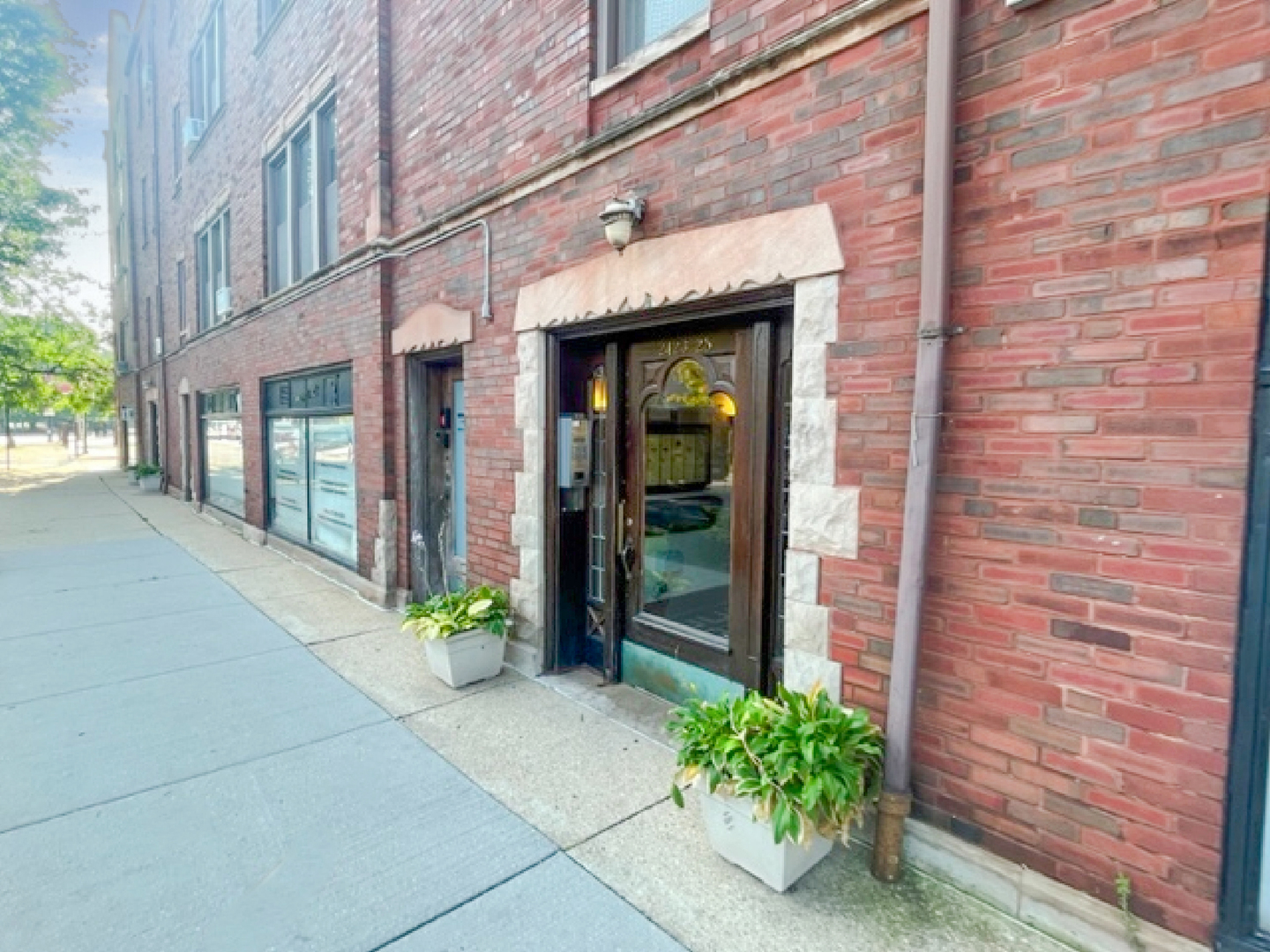 2425 West Pratt Boulevard, Unit 3I Chicago, IL 60645 - Photo 3 of 16 a view of a brick house with potted plants