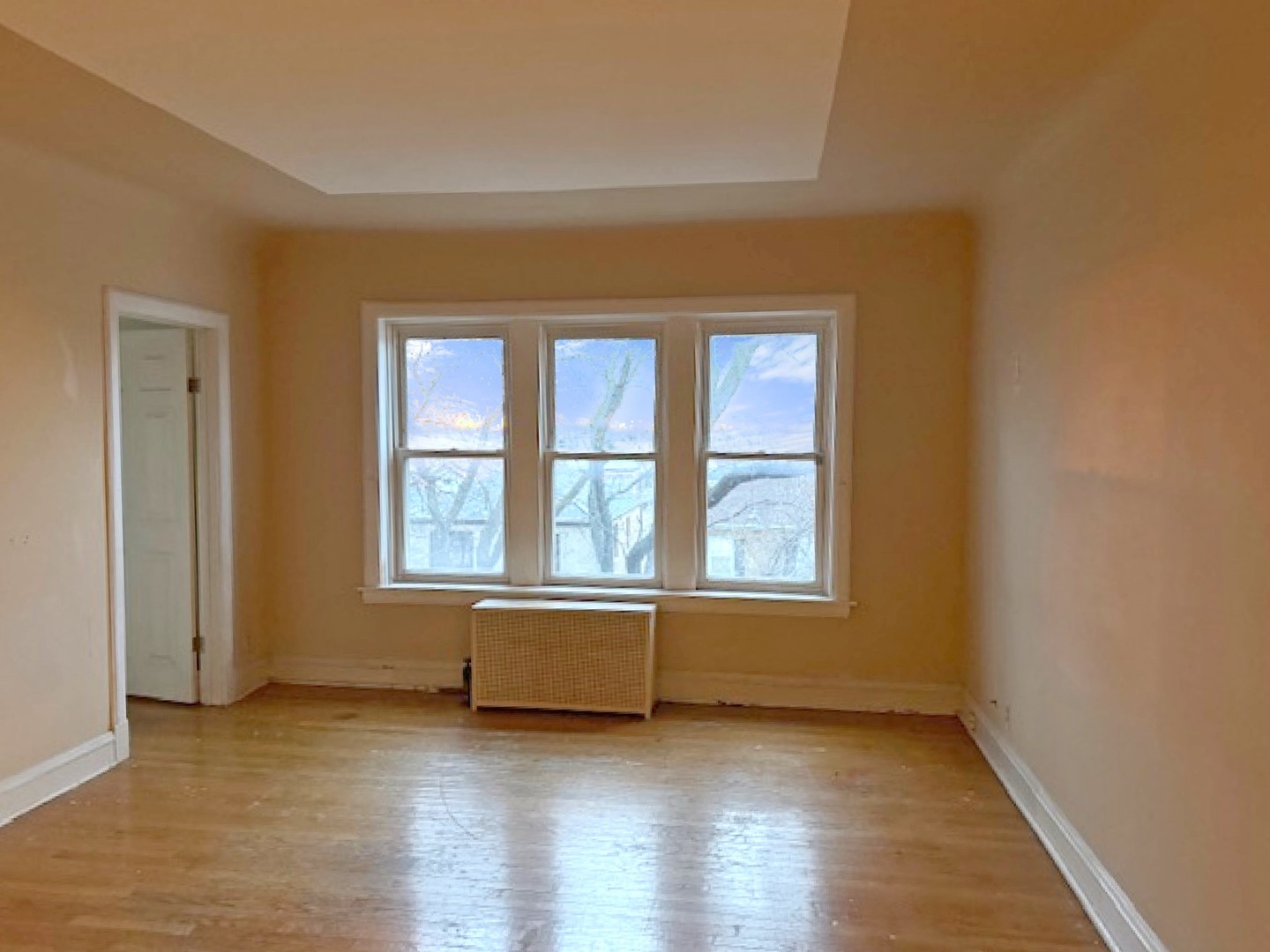 2425 West Pratt Boulevard, Unit 3I Chicago, IL 60645 - Photo 5 of 16 an empty room with wooden floor and windows