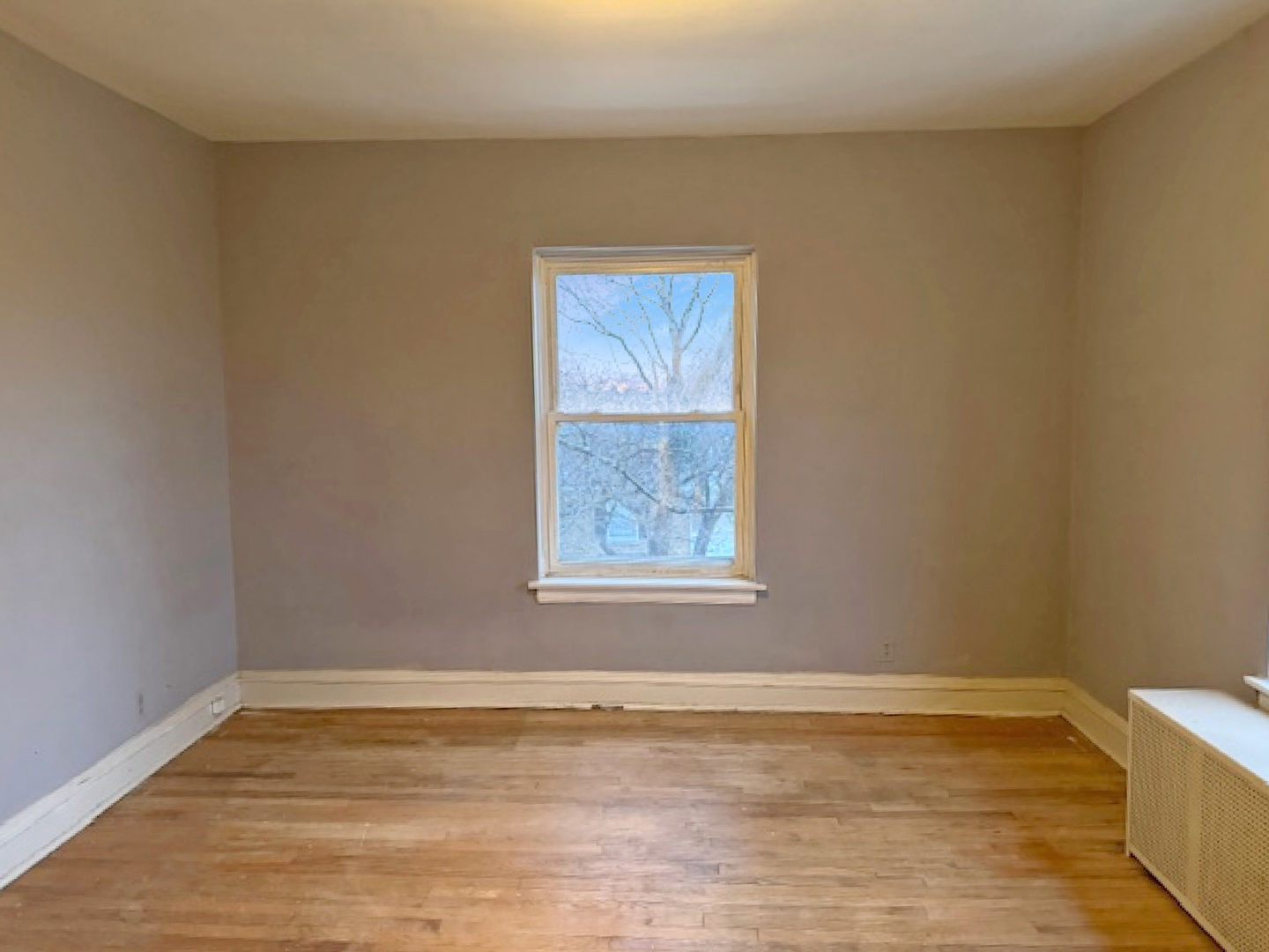 2425 West Pratt Boulevard, Unit 3I Chicago, IL 60645 - Photo 7 of 16 a view of an empty room with window and wooden floor