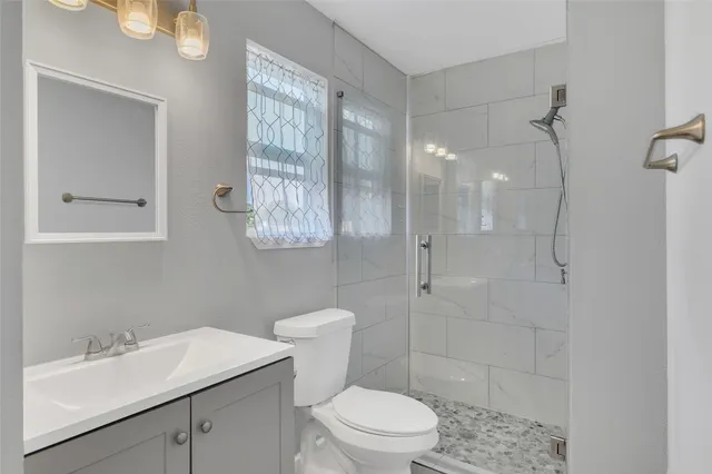 an empty room with wooden floor chandelier and window