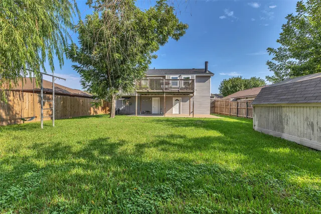 a balcony with wooden floor table and chairs