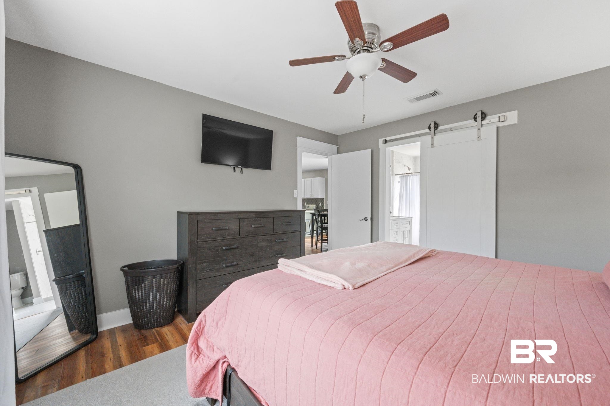 1107 North Oak Street Loxley, AL 36551 - Photo 12 of 40 Bedroom with ceiling fan, a barn door, and dark hardwood / wood-style floors