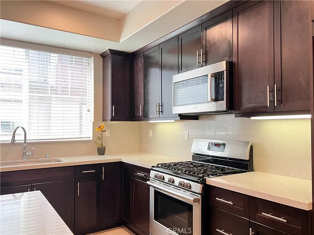 a kitchen with stainless steel appliances wooden cabinets and a stove top oven