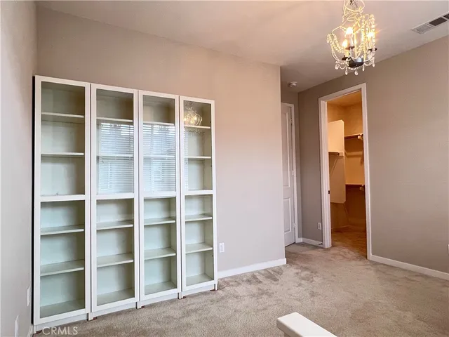 a view of a room with a cabinet and a chandelier