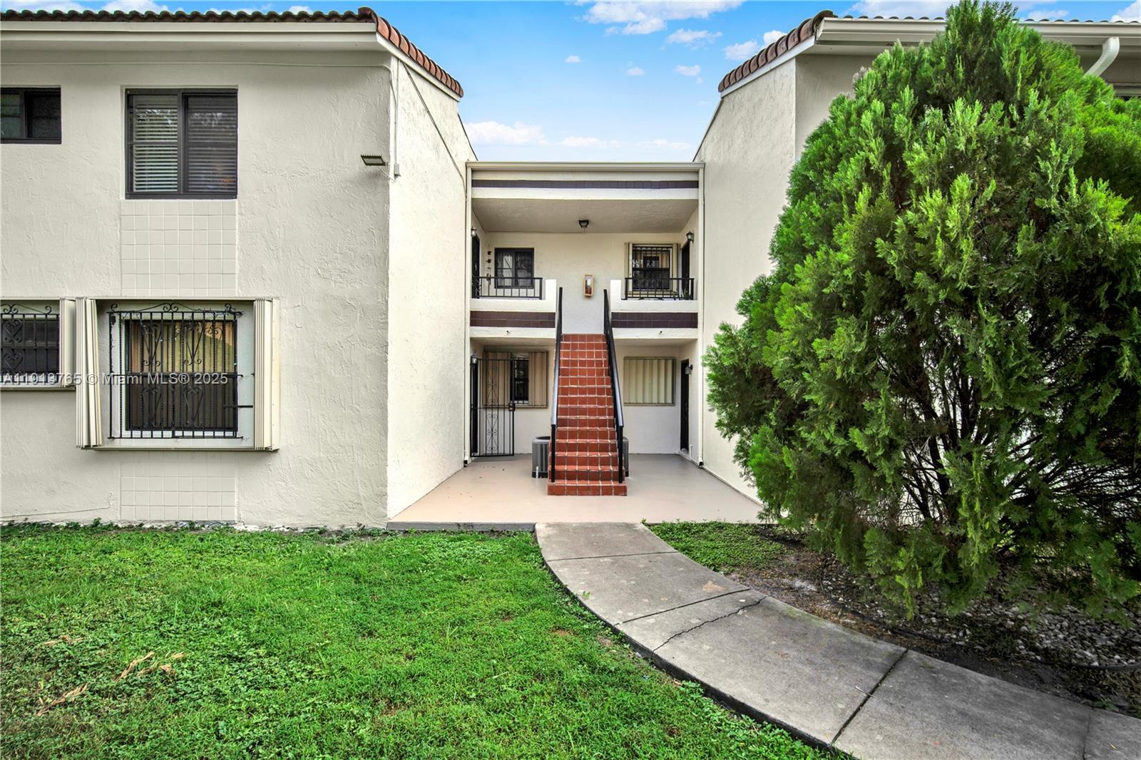 10857 Northwest 7th Street, Unit 2417 Miami, FL 33172 - Photo 1 of 35 a front view of a house with a yard and garage
