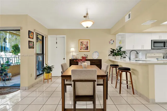 a dining room with kitchen island a table and chairs