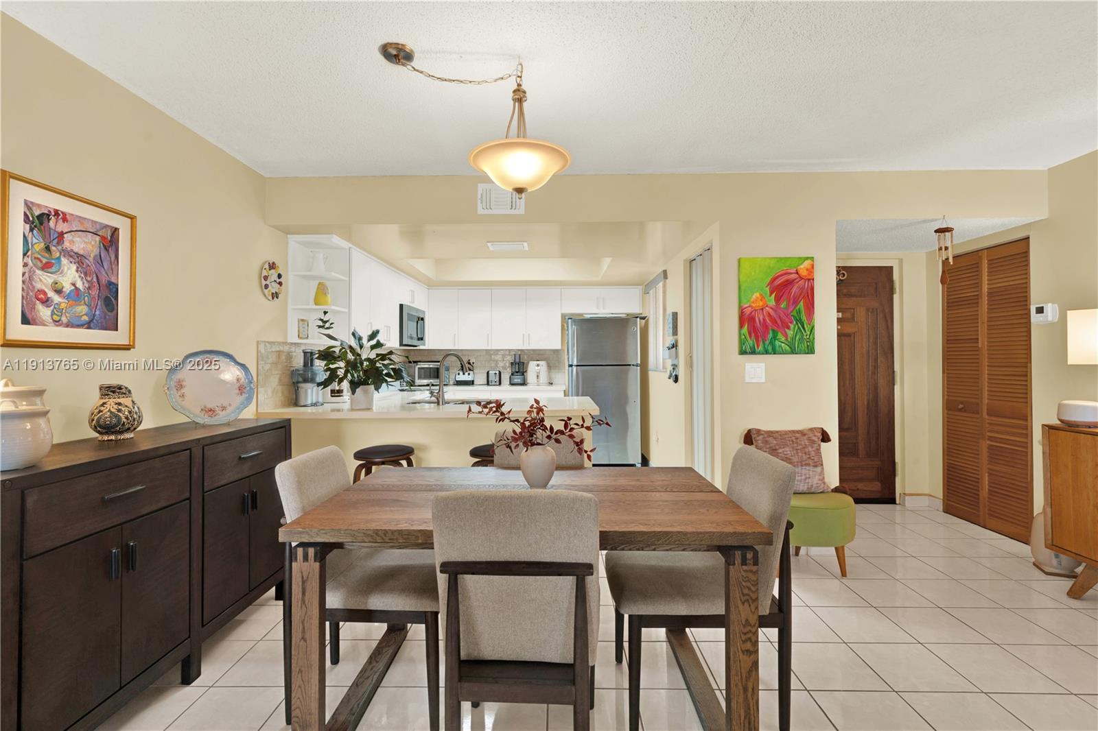 10857 Northwest 7th Street, Unit 2417 Miami, FL 33172 - Photo 15 of 35 a view of a dining room with furniture and a chandelier