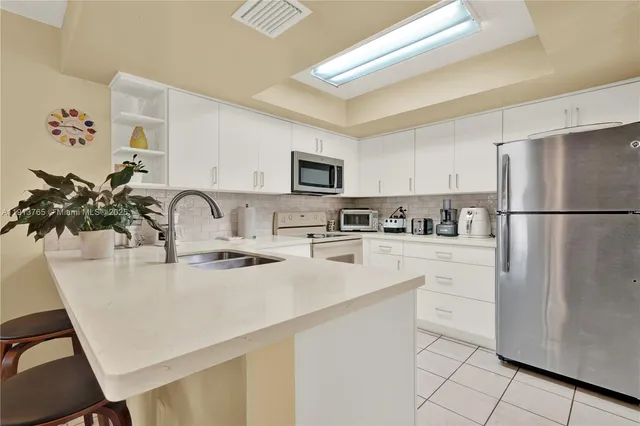 a kitchen with a refrigerator and a sink