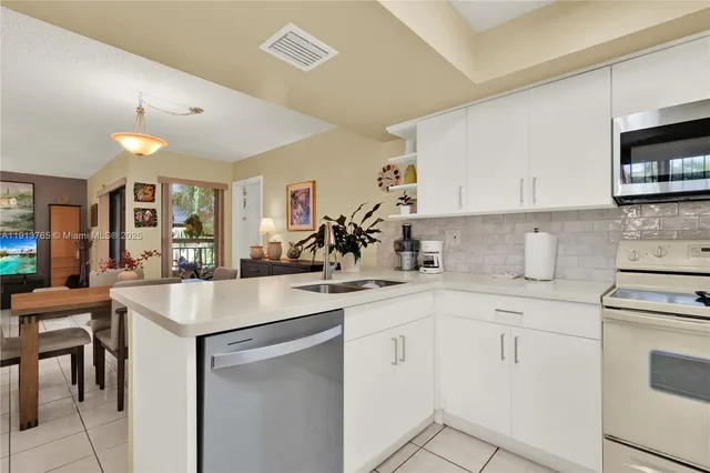 a kitchen with appliances a sink and cabinets