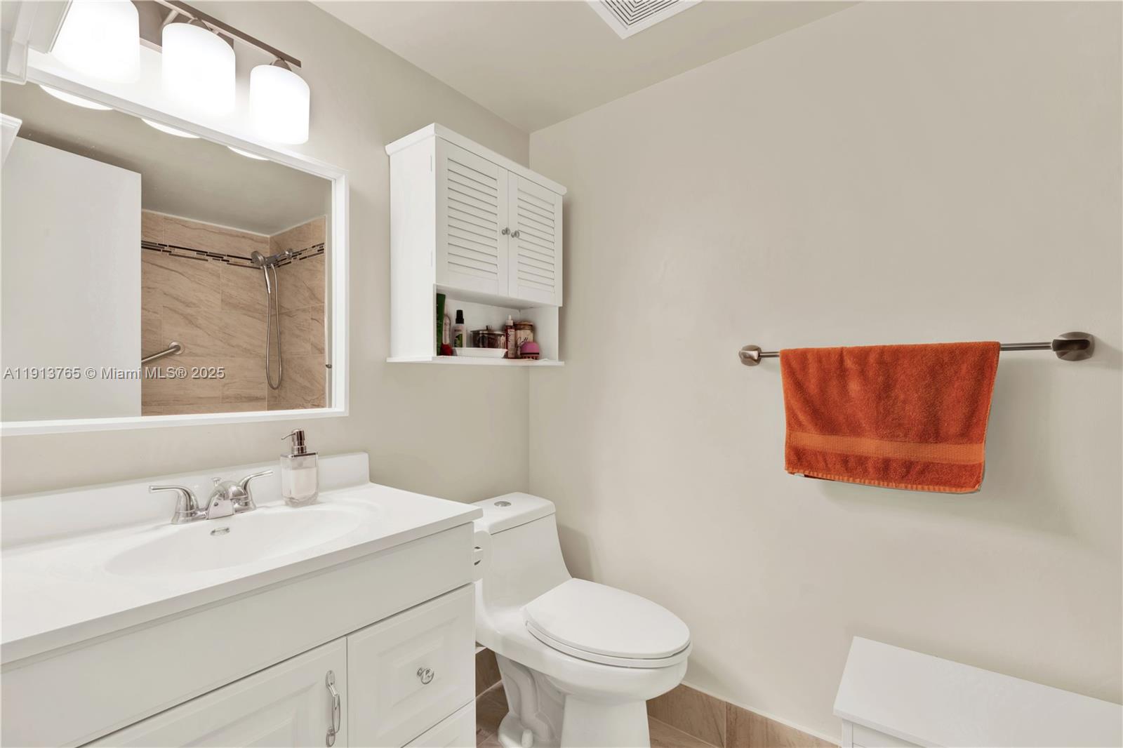 10857 Northwest 7th Street, Unit 2417 Miami, FL 33172 - Photo 33 of 35 a bathroom with a toilet sink vanity and mirror