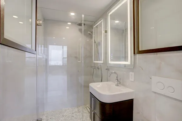 a bathroom with a sink shower and a mirror