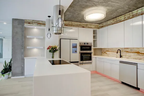 a kitchen with stainless steel appliances kitchen island granite countertop a refrigerator and a stove