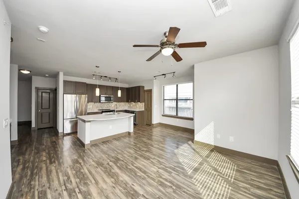 a view of a refrigerator in kitchen and an empty room