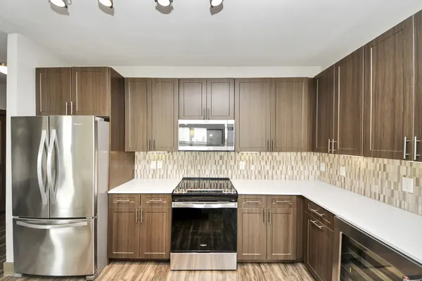 a kitchen with stainless steel appliances kitchen island granite countertop a sink a counter space and cabinets