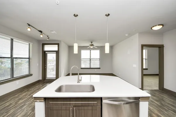 a kitchen with stainless steel appliances kitchen island granite countertop a sink a counter space and cabinets