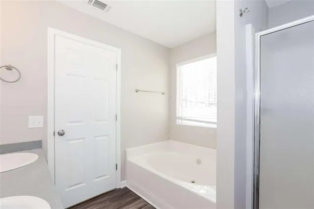 a bathroom with a bathtub a toilet and a shower